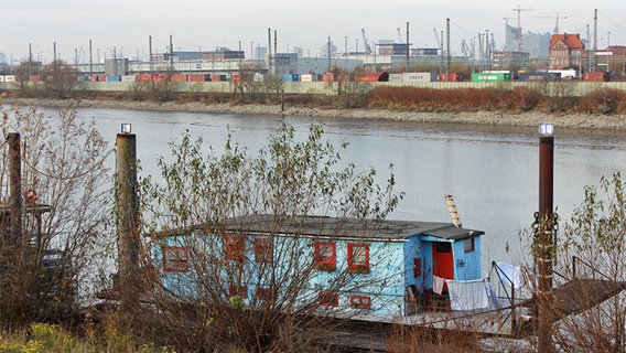 Ein Hausboot liegt im Wilhelmsburger Spreehafen, im Hintergrund Industriebauten und die Elbphilharmonie. © NDR Foto: Daniel Sprenger