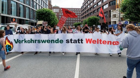 Aktivisten von "Fridays for Future" laufen hinter einem Transparent mit der Aufschrift "Verkehrswende statt Weltende". © Markus Scholz/dpa 