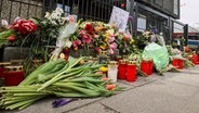 Nach einem Amoklauf mit acht Toten: Blumen und Kerzen vor dem Eingangsbereich eines Gemeindehauses der Zeugen Jehovas in Hamburg. © picture alliance/dpa Foto: Christian Charisius