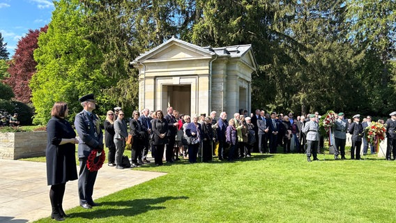 Mehrere Teilnehmer bei der zentralen Gedenkveranstaltung zum Ende des Zweiten Weltkriegs vor 80 Jahren auf dem Ohlsdorfer Friedhof in Hamburg. © NDR Foto: Anna-Lena Ehle