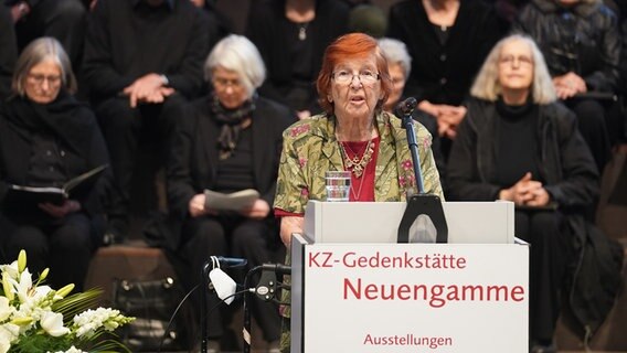 Helga Melmed aus den USA, Überlebende des KZ Neuengamme, spricht zu den Gästen während der Gedenkfeier in der KZ Gedenkstätte Neuengamme. © picture alliance/dpa Foto: Marcus Brandt