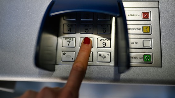 Eine Frau gibt ihre Geheimnummer an einem Geldautomaten ein. © IMAGO / Michael Weber Foto: Michael Weber