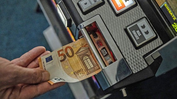 Ein Geldschein wird in einen Glücksspielautomat geschoben. © picture alliance/dpa Foto: Bernd Thissen