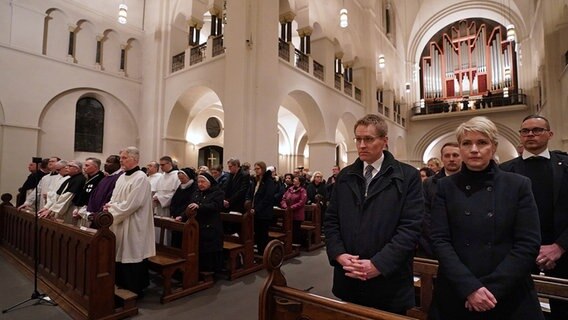 Manuela Schwesig (r, SPD), Ministerpräsidentin von Mecklenburg-Vorpommern, und Daniel Günther (2.v.r, CDU), Ministerpräsident von Schleswig-Holstein, stehen zu Beginn des Pontifikalrequiems für den gestorbenen Papst Benedikt XVI. im St. Marien-Dom. © picture alliance/dpa Foto: Marcus Brandt