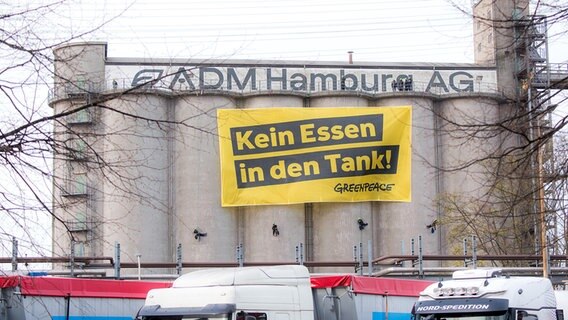Greenpeace-Aktivisten haben ein Banner mit der Aufschrift "Kein Essen in den Tank!" an einem Silo ausgebreitet. © picture alliance/dpa Foto: Daniel Bockwoldt