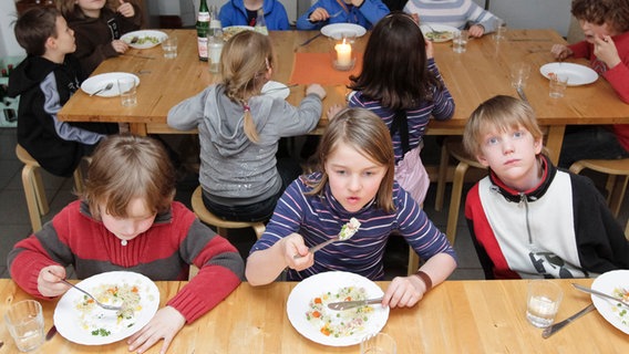 Kinder in einer Grundschule nehmen ihr Mittagessen ein. © picture alliance / dpa Foto: Markus Scholz