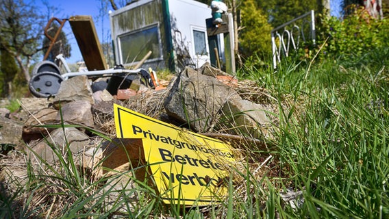 Ein verwahrlostes Grundstück mit einem Schild "Privatgrundstück - Betreten verboten". © IMAGO / Christian Ohde Foto: Christian Ohde