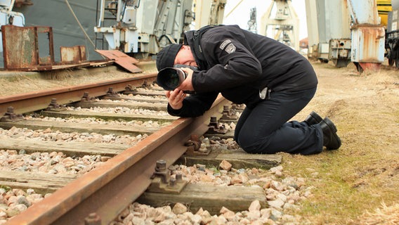 Fotograf Vallbracht liegt auf Bahnschinenen © NDR Foto: Carolin Fromm