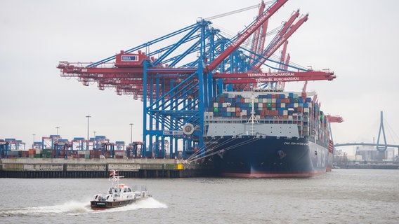 Ein Containerschiff liegt am Hamburger Containerterminal Burchardkai, während ein Lotsenboot vorbeifährt. © picture alliance / dpa Foto: Daniel Bockwoldt