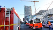 Einsatzfahrzeuge der Feuerwehr stehen in der Nähe einer Baustelle in der Hafencity, auf der es einen tödlichen Unfall gegeben hat. © Bodo Marks/dpa 