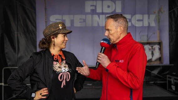 NDR 90,3 Moderator Michi Wittig steht auf der NDR Bühne mit der Künstlerin Fidi Steinbeck. © NDR Foto: Axel Herzig