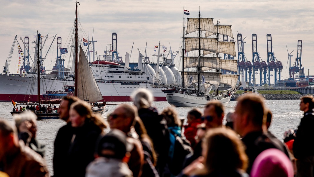 Besucher des Hamburger Hafengeburtstags beobachten Schiffe auf der Elbe.