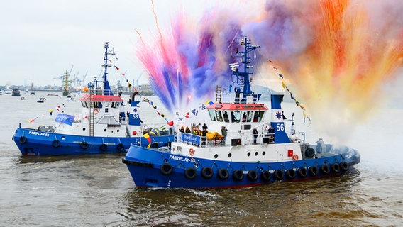 Bunte Pyrotechnik wird zum Ende des traditionellen Schlepperballetts an Bord der Schlepper auf der Elbe vor der Elbphilharmonie gezündet. © picture alliance/dpa Foto: Jonas Walzberg