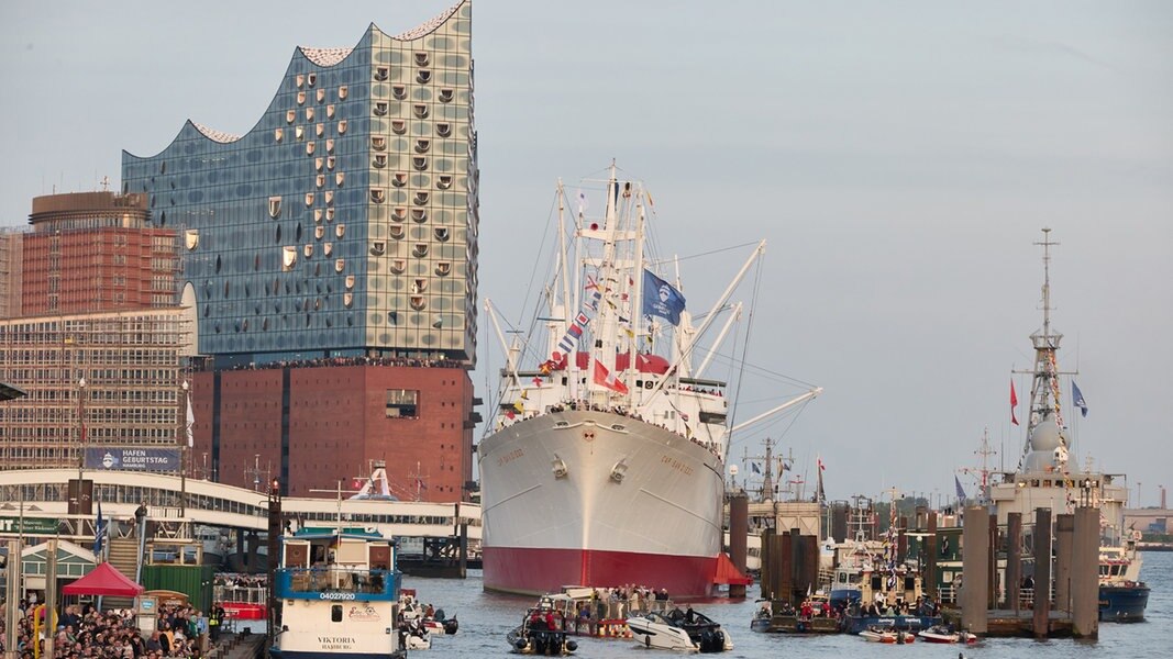Zahlreiche Besucher haben sich während des 835. Hamburger Hafengeburtstages nach Sonnenuntergang an den Landungsbrücken versammelt.