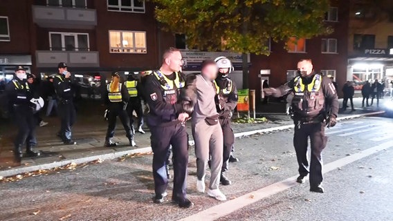 Ein junger Mann wird von Polizeibeamten abgeführt. © TV- NEWS KONTOR / dslrnews Foto: TV- NEWS KONTOR / dslrnews