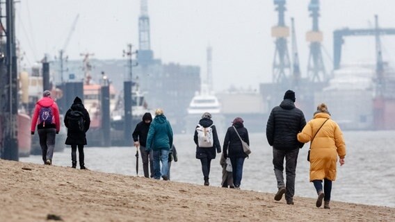 Spaziergänger sind am Elbstrand bei Övelgönne unterwegs. © picture alliance / dpa Foto: Markus Scholz