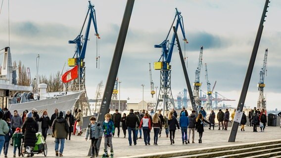 Hamburger und Touristen gehen auf der Hochwasserschutzanlage am Baumwall spazieren. © picture alliance / dpa Foto: Markus Scholz