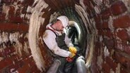 Ein Mitarbeiter von Hamburg Energie arbeitet in einem Tunnel.  Foto: Ulrich Perrey