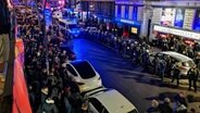 Mehrere Menschen stehen vor Polizeikräften vor der Kneipe "Elbschlosskeller" auf St. Pauli. © HamburgNews Verkauf 