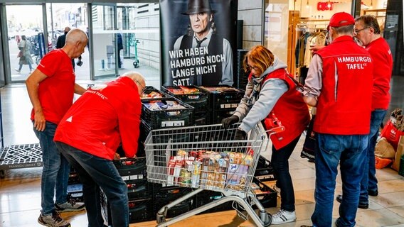 Mitarbeiter der Hamburger Tafel sortieren im Einkaufszentrum Europa Passage gespendete Lebensmittel. © Axel Heimken/dpa 