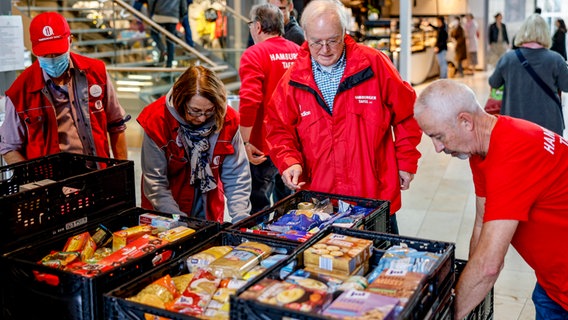 Mitarbeiter der Hamburger Tafel sortieren im Einkaufszentrum Europa Passage gespendete Lebensmittel. © Axel Heimken/dpa 
