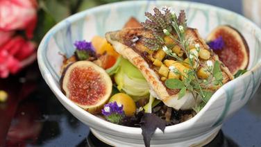 The food in the Buddha's hand turns yellow in a bowl.  © NDR Photo: Dave Hänsel