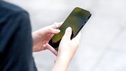 Eine Frau hält ein Smartphone in der Hand. © picture alliance / dpa-tmn Foto: Bernd Diekjobst