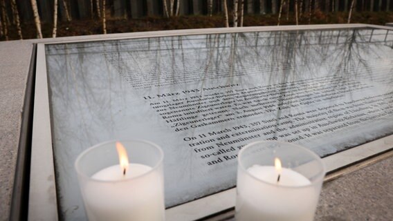 Kerzen stehen auf den Namenstafeln zur Erinnerung an die Deportierten an der Gedenkstätte Hannoverscher Bahnhof in der Hafencity. Am internationalen Gedenktag für den Holocaust wurde der Opfer des Nationalsozialismus gedacht. © picture alliance/dpa Foto:  Christian Charisius