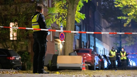 Polizisten sichern einen abgesperrten Tatort in Hamburg-Harburg. Dort wurde auf zwei Männer geschossen. © picture alliance / dpa Foto: Jonas Walzberg