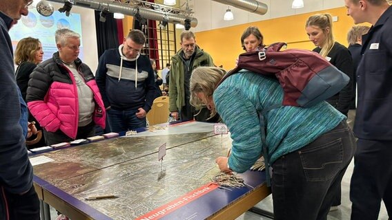Bei einer Informationsveranstaltung zur Zukunft der B73 in Hamburg schauen sich teilnehmende eine Karte an. © NDR Foto: Isabelle Wildberger