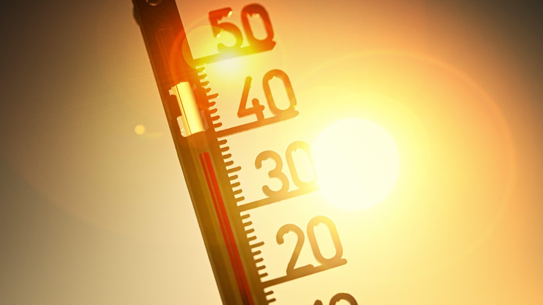 Ein Thermometer vor einer Sonne zeigt hohe Temperaturen an.