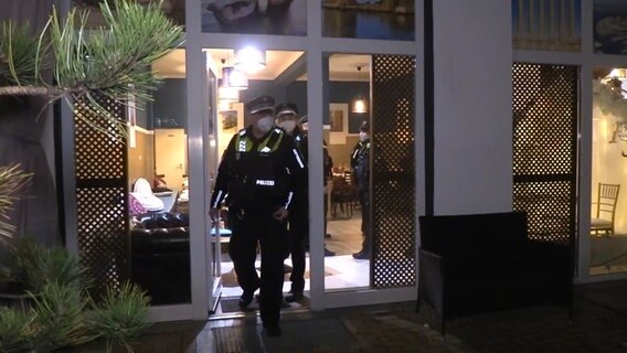 Polizeibeamte verlassen ein Restaurant in Borgfelde. © NonstopNews Foto: Screenshot
