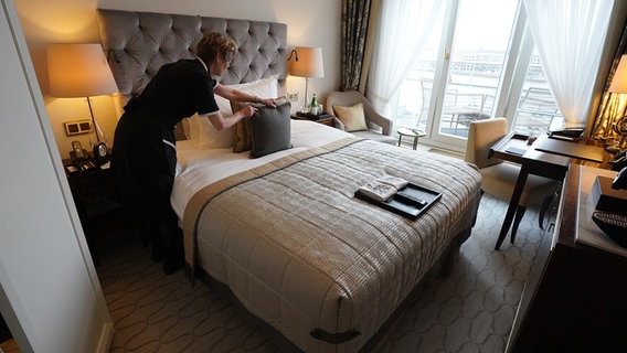 Eine Frau richtet ein Hotelzimmer in Hamburg her. © picture alliance/dpa Foto: Marcus Brandt