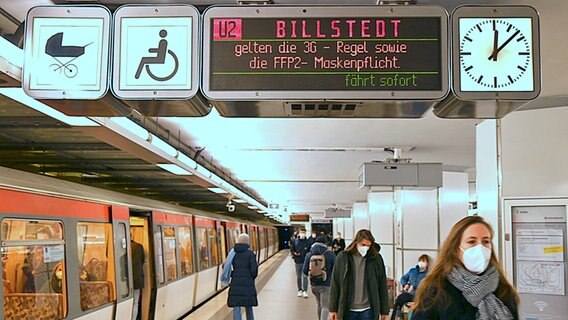 Am Bahnsteig der U-Bahn wird angezeigt, dass eine FFP2-Maskenpflicht in den Bussen und Bahnen des HVV gilt.  