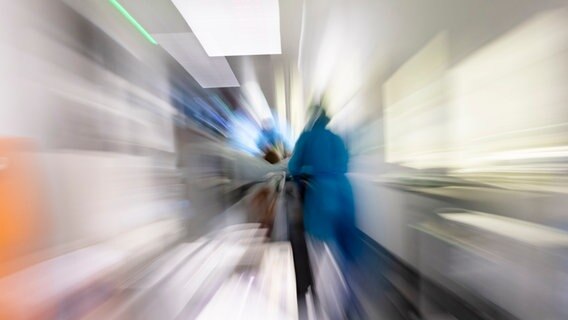 Pflegekräfte transportieren einen Patienten auf einem Gang einer Intensivstation. © dpa Foto: Frank Molter