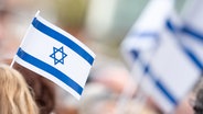 Teilnehmer einer Demonstration tragen Israel-Fahnen. © picture alliance / dpa Foto: Jonas Walzberg