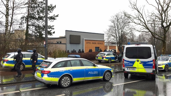 Einsatzkräfte der Polizei stehen vor der Otto-Hahn-Schule in Jenfeld. © picture alliance/dpa Foto: Daniel Bockwoldt