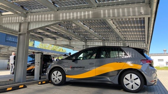 Ein Fahrzeug steht auf einem Parkplatz, der mit Solarzellen überdacht ist. © NDR / Reinhard Postelt Foto: Reinhard Postelt