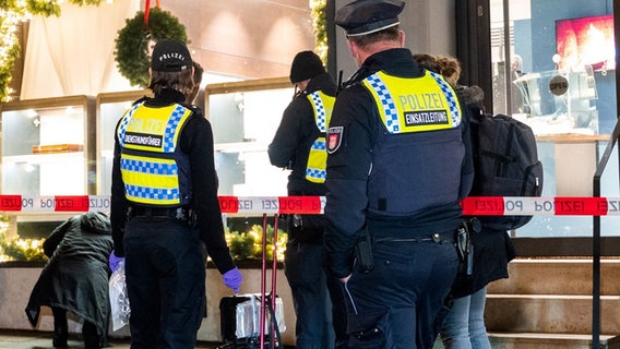Polizisten stehen nach einem Überfall auf einen Juwelier in der Neustadt vor dem Gebäude. © Daniel Bockwoldt/dpa Foto: dpa-Bildfunk