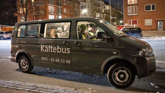 Ehrenamtliche Helferinnen sitzen mit einem Obdachlosen im Hamburger Kältebus. © picture alliance / dpa 