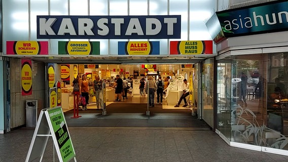 Mehrere Personen gehen durch den Eingangsbereich eines Einkaufgeschäfts. © NDR Foto: Karsten Sekund