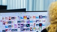 Eine Ermittlerin sitzt vor Monitoren mit unkenntlich gemachten Fotografien, die teilweise sexuellen Missbrauch zeigen. © picture alliance/dpa Foto: Rolf Vennenbernd