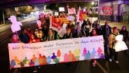 Teilnehmerinnen und Teilnehmer einer Demonstration von Kita-Beschäftigten und Eltern mit Kindern laufen in einem Demonstrationszug am Bahnhof Dammtor. © picture alliance / dpa 