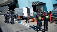 Klimaaktivisten haben sich auf der Fahrbahn der Autobahn 7 festgeklebt und blockieren so die Zufahrt des Elbtunnels in Richtung Norden. © picture alliance/dpa Foto: Daniel Bockwoldt