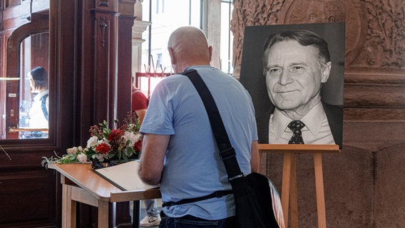 Ein Mann trägt sich im Hamburger Rathaus in das Kondolenz-Buch für den verstorbenen Bürgermeister Hans Ulrich Klose ein. © pictue alliance / dpa Foto: Markus Scholz
