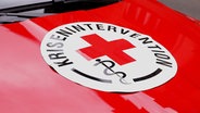 Ein Aufkleber mit der Aufschrift "Krisenintervention" klebt auf der Motorhaube eines Autos. © dpa Foto: Tino Plunert