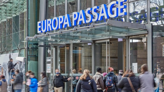 Menschen gehen durch den Eingang der Europa Passage in der City. Hamburg hat im Einzelhandel die 2G-Regel gekippt. Fürs Shoppen reicht nun eine FFP2-Maske.  Foto: Georg Wendt