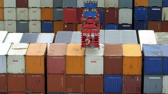 Sogenannte Lascher lösen auf dem am neuen Containerterminal in Hamburg-Altenwerder liegenden Containerschiff "Hamburg Express" die Befestigungen an Containern. © picture alliance / dpa Foto: Kay Nietfeld