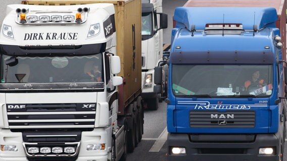 Sattelschlepper mit Containern fahren im Hamburger Hafen. © picture alliance 