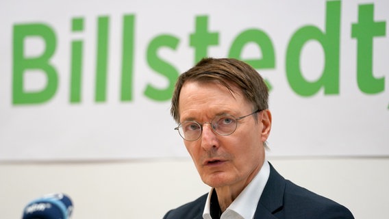 Bundesgesundheitsminister Karl Lauterbach spricht in Hamburg in Mikrofone - im Hintergrund ist der Schriftzug "Billstedt" zu sehen. © picture alliance / dpa Foto: Marcus Brandt